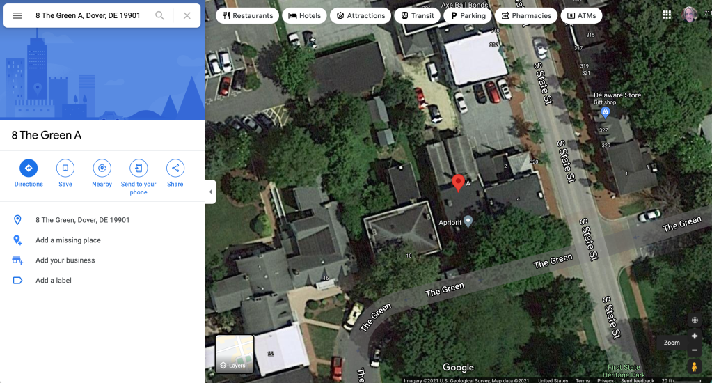 Screenshot of the satellite view of the address for 41 Pushups, LLC shows the building near the intersection of South State and The Green in Dover Delaware. The building has a flat roof and appears to be barely larger than the crowns of the surrounding trees. 